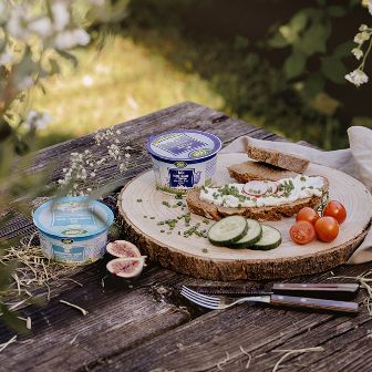 Jausenplatte mit Schaf- und Ziegentopfen auf Holztisch